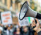 closeup-megaphone-protest-with-blurred-signs-demonstrators-background
